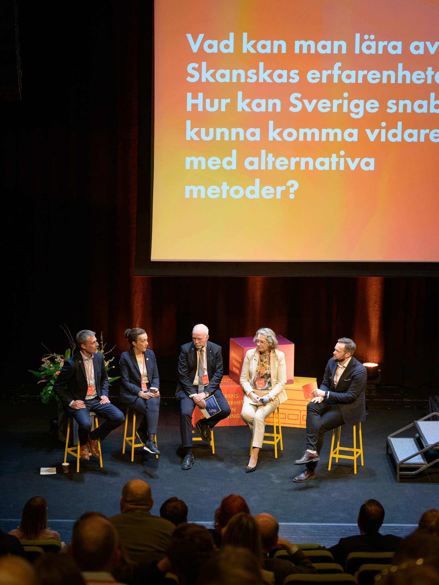 Fem personer sitter på scen i en paneldiskussion under Järnvägsforum Norr. På storskärmen ovanför syns texten ”Vad kan man lära av Skanskas erfarenheter? Hur kan Sverige snabbare kunna komma vidare med alternativa metoder?”.